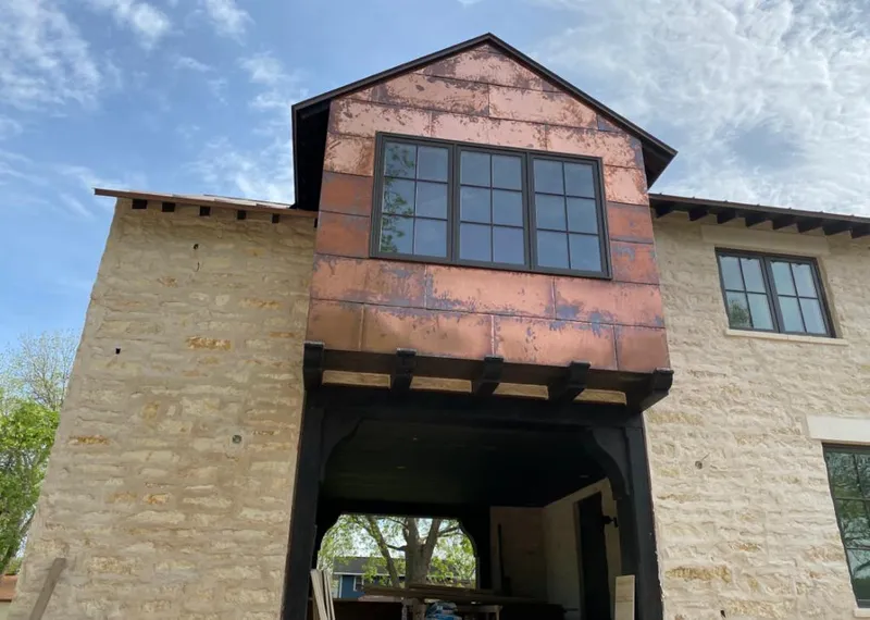 Copper metal panel facade on a stone building for Skylight Installation in Brownville